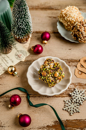 Rocher Praliné Noir : cœur de praliné noisette fait maison est sublimé par un enrobage de chocolat noir puissant, orné d'éclats de noisettes et pistache, vegan et sans gluten réalisé par végéta'ly